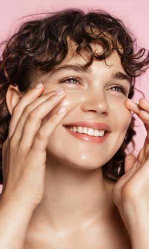Beautiful,Natural,Girl,Smiling,,Rubbing,Her,Face,With,Facial,Cleanser